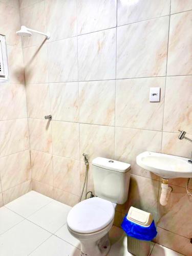 a bathroom with a toilet and a sink at Toca do coelho in Aquiraz