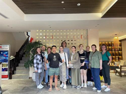 a group of people posing for a picture in a store at Lingxi Riverview Boutique Homestay - Phoenix Ancient Town in Fenghuang