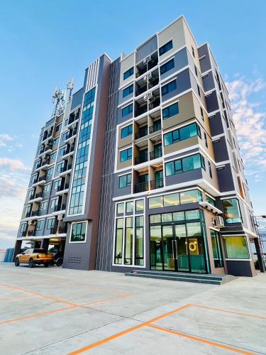 a large building with a parking lot in front of it at เวลโกรว์ โฮเทล - Wellgrow Hotel in Ban Bang Kha