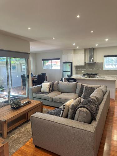 a living room with two couches and a kitchen at L'barza Delightful Family Townhouse with courtyard - 3 bedrooms in Shepparton
