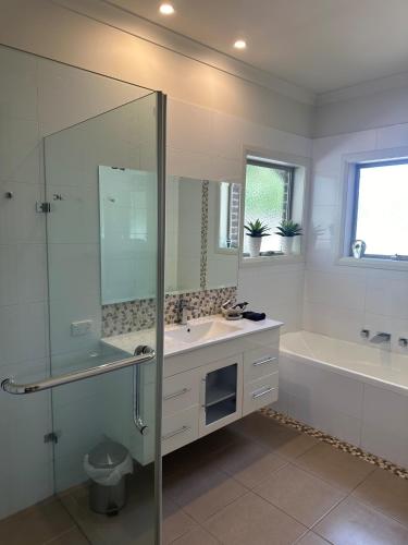 Un baño con ducha, lavabo y bañera. en Lbarza Delightful 3BR Central Townhouse with courtyard, en Shepparton
