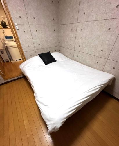 a bedroom with a white bed with a black pillow at Amika First 303 AF33 in Tokyo