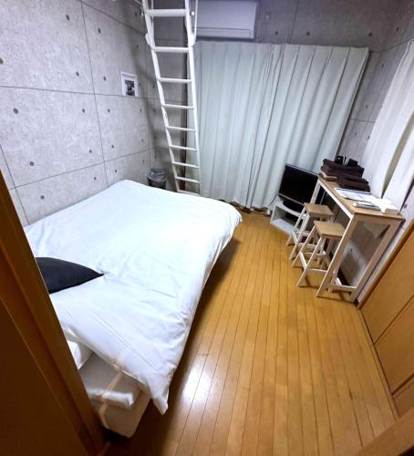 a bedroom with a white bed and a ladder at Amika First 303 AF33 in Tokyo