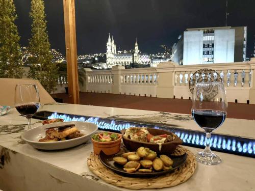 a table with a plate of food and two glasses of wine at Boutique Hotel in Quito Hotel Casona 1914 in Quito