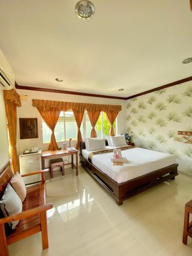 a large bedroom with two beds and a couch at Dhammachart RiverView in Samut Songkhram