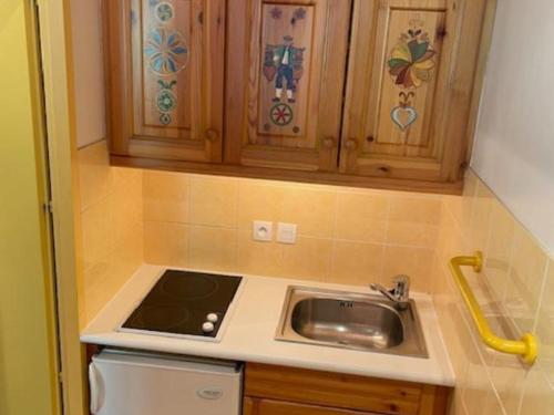 une cuisine avec un évier et des armoires en bois dans l'établissement Les Menuires - Appart 4 pers, 32m², Wifi, Animaux admis - FR-1-574-72, aux Menuires