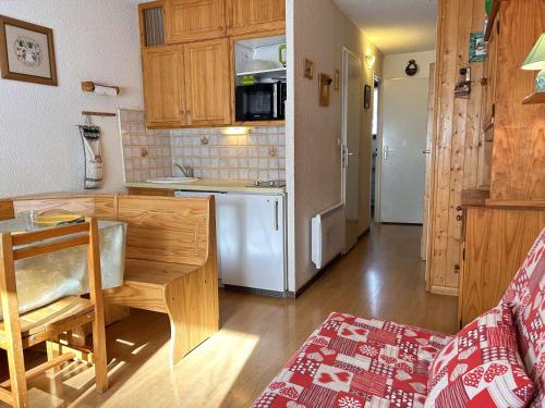 une cuisine avec une table et un réfrigérateur blanc dans l'établissement Studio à Risoul 1850, 4 couchages, proche pistes - FR-1-330-584, à Risoul