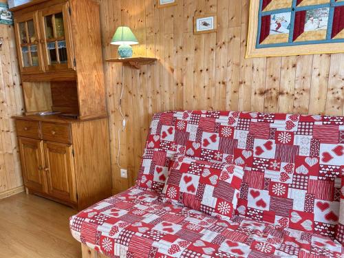 un salon avec un canapé avec une couverture rouge et blanche dans l'établissement Studio à Risoul 1850, 4 couchages, proche pistes - FR-1-330-584, à Risoul