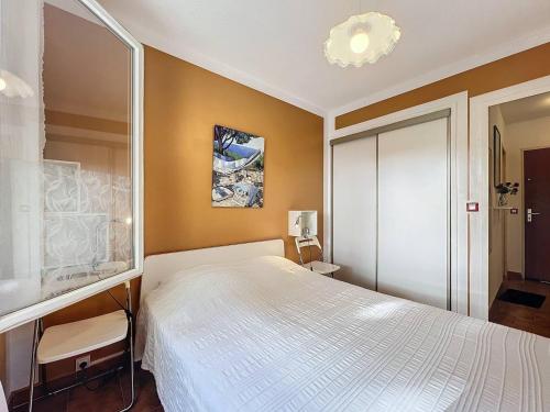 - une chambre avec un lit blanc et un lustre dans l'établissement Appartement 2-4 pers, proche plage, parking privatif - FR-1-770-40, à Saint-Cyr-sur-Mer