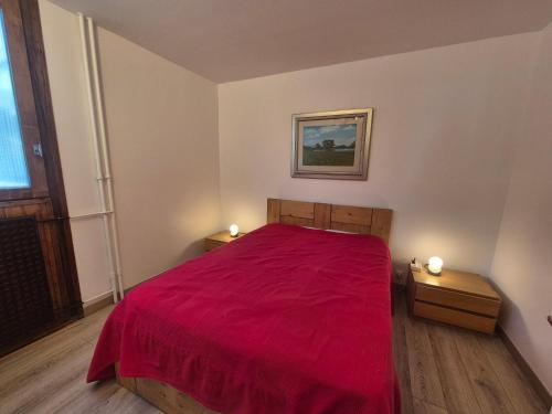 - une chambre avec un lit rouge et 2 tables de chevet dans l'établissement Confort 2 pièces rénové près pistes et commerces avec Wifi à Tignes - FR-1-502-593, à Tignes