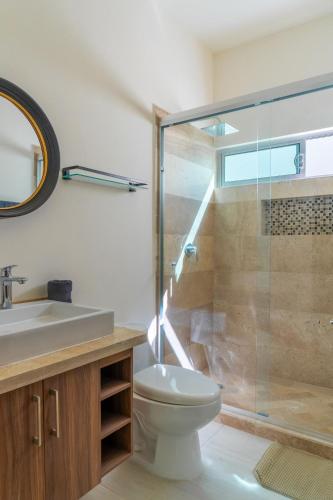 a bathroom with a toilet and a glass shower at Casa Colibrí in La Paz