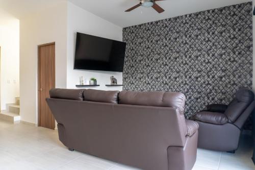 a living room with a couch and a flat screen tv at Casa Colibrí in La Paz