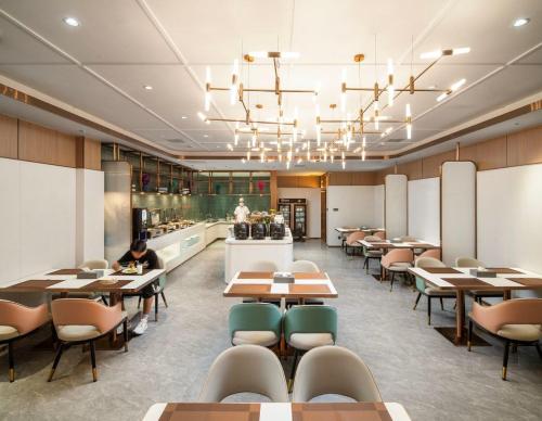 a restaurant with tables and chairs and a counter at Mehood EZZI Hotel Huashan Visitor Center in Huayin
