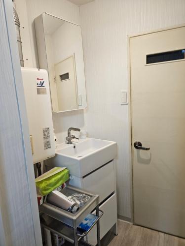 a small bathroom with a sink and a mirror at YOYOGi STAY in Tokyo