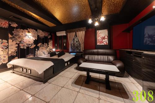 a bedroom with a bed and a couch and a tv at M'SCLUB OsakaHirano AdultOnly in Osaka