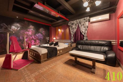 a bedroom with a bed and a leather couch at M'SCLUB OsakaHirano AdultOnly in Osaka