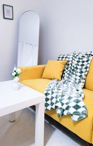 a living room with a yellow couch and a table at Seoul 리베스폴 3room KSPO-DOM Family trip in Seoul
