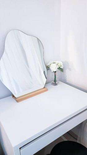 a white table with a vase of flowers on it at Seoul 리베스폴 3room KSPO-DOM Family trip in Seoul