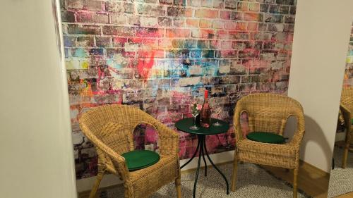 two chairs and a table in front of a brick wall at Studio Viva - Cosy Flat in Budapest - Free Parking in Budapest
