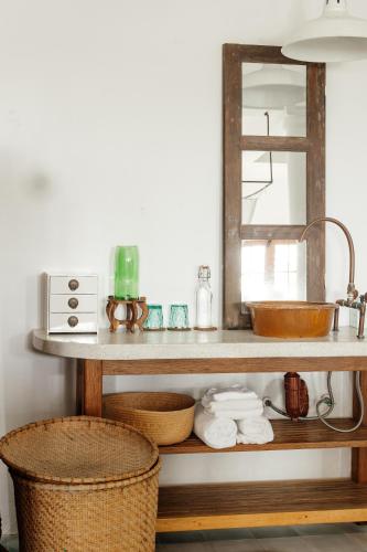 a bathroom shelf with a sink and a mirror at Heron House in Hoi An