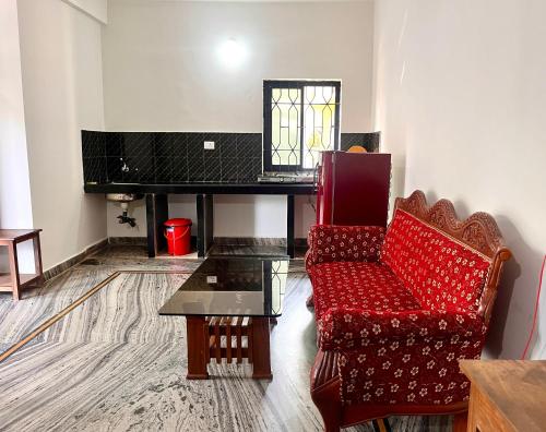 a living room with a red chair and a piano at Morjim Sunset Guesthouse - 300 meter to Morjim Beach in Morjim