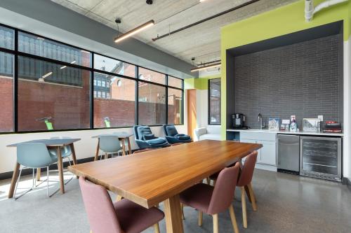a dining room with a wooden table and chairs at CozySuites Mass w parking lounge & roof deck #26 in Indianapolis