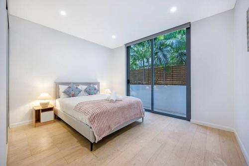 a bedroom with a bed and a large window at Central Eastwood 3BR - Close to Shops & Transport in Sydney