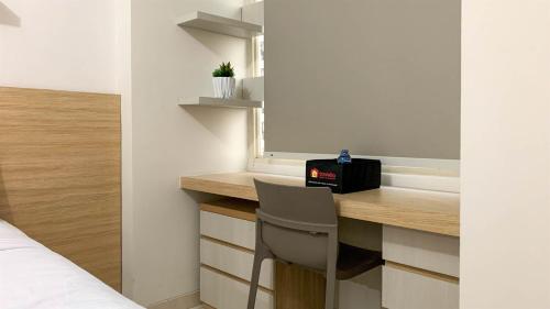 a bedroom with a desk with a chair next to a bed at Comfort Studio Room at Margonda Residence 5 Apartment By Travelio in Depok