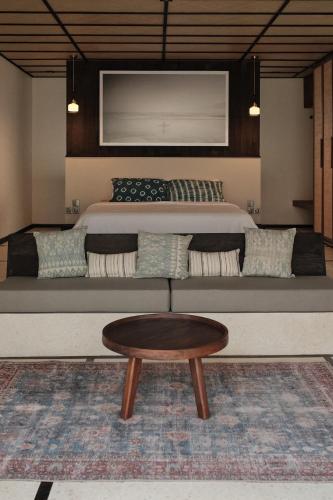 a bedroom with a bed and a coffee table at New Little Ripper Boutique Hotel in Tanah Lot
