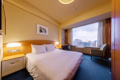 a hotel room with a bed and a large window at Shinagawa Prince Hotel in Tokyo