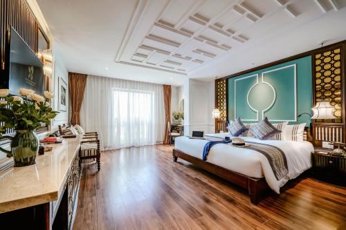 a large bedroom with a large bed and a desk at Gallery Hotel & Spa - Le Pavillon Hoi An Group in Hoi An