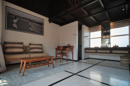 a living room with a bench and a table at New Little Ripper Boutique Hotel in Tanah Lot