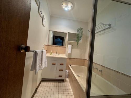 a bathroom with a shower and a tub and a sink at Church St in Bright