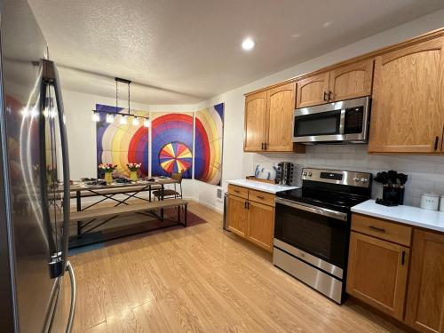 a kitchen with a refrigerator and a table in it at Soaring Spirit - Hot Tub, Pool Table, Arcades, 2 kitchens in Walla Walla