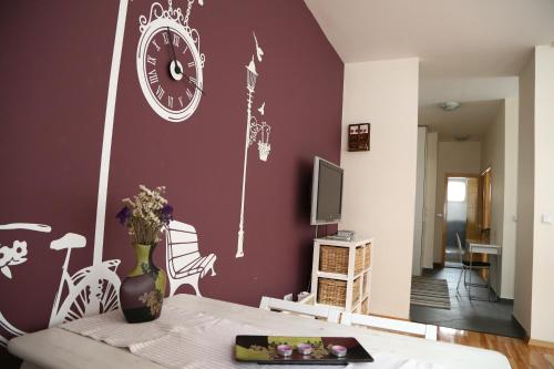 uma sala de estar com um relógio na parede em Konak Apartment em Saraievo