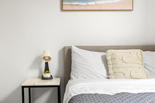 a bed with white sheets and a lamp on a side table at Rustic Double Room - Central Location in Kensington - Shared Bathroom in Sydney