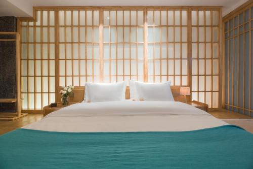 a large bed in a room with a large window at Dali Muhai Island Designer Seaview Manor in Dali
