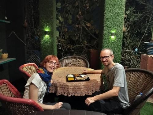 a man and woman sitting at a table with a plate of food at Kishan Home Stay in Mathura