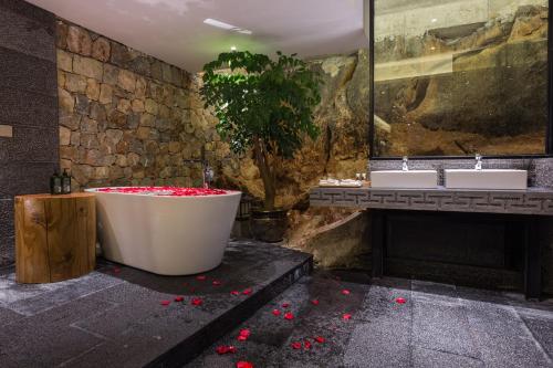 a bathroom with a tub and two sinks and a tree at Dali Muhai Island Designer Seaview Manor in Dali