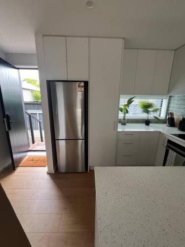 a kitchen with a stainless steel refrigerator in it at Luxury And Serene 2 Bed Near CBD With Parking in Christchurch
