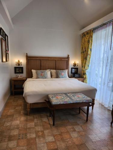 a bedroom with a large bed and two windows at La Campagne Villa Chiangmai in Chiang Mai