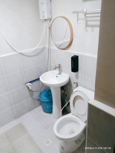 ein Badezimmer mit Toilette, Waschbecken und Spiegel in der Unterkunft Alex's Staycation in Cebu City