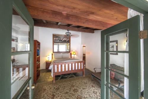 a bedroom with a bed and a mirror on the wall at Korakia Pensione in Palm Springs