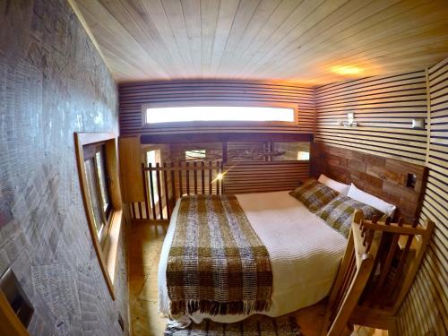 a small bedroom with a bed in a room at La Casa Del Árbol De Chiloé in Castro