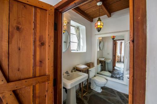 a bathroom with a white sink and a toilet at Korakia Pensione in Palm Springs
