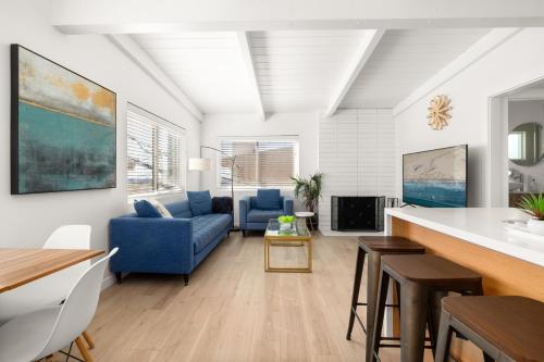 a living room with a blue couch and a table at NEW! Ocean View Mid-Century Modern Beach House in Manhattan Beach