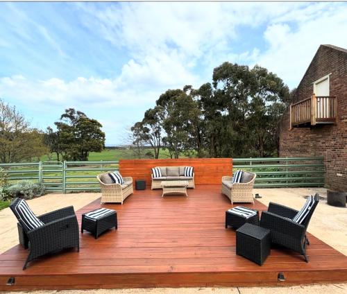 a deck with couches and chairs on a patio at CLAYFIELD HOMESTEAD - rustic country accommodation in Bishopsbourne