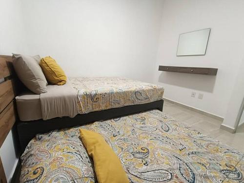 two beds sitting next to each other in a room at Departamento Colibrí in Playa del Carmen