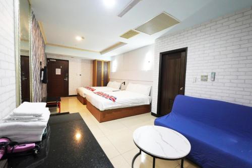 a hotel room with a bed and a blue couch at I Hi Loveriver Hotel in Kaohsiung