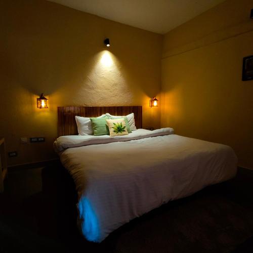 a bedroom with a large white bed with two pillows at Cafe Buransh in Sari